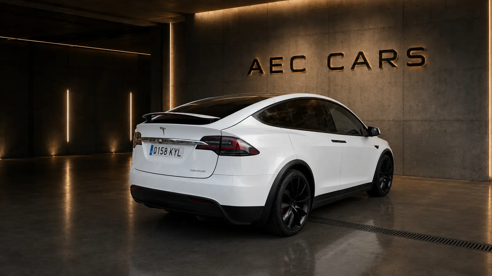 Tesla Model X visto desde atrás en el espacio de hormigón de AEC Cars